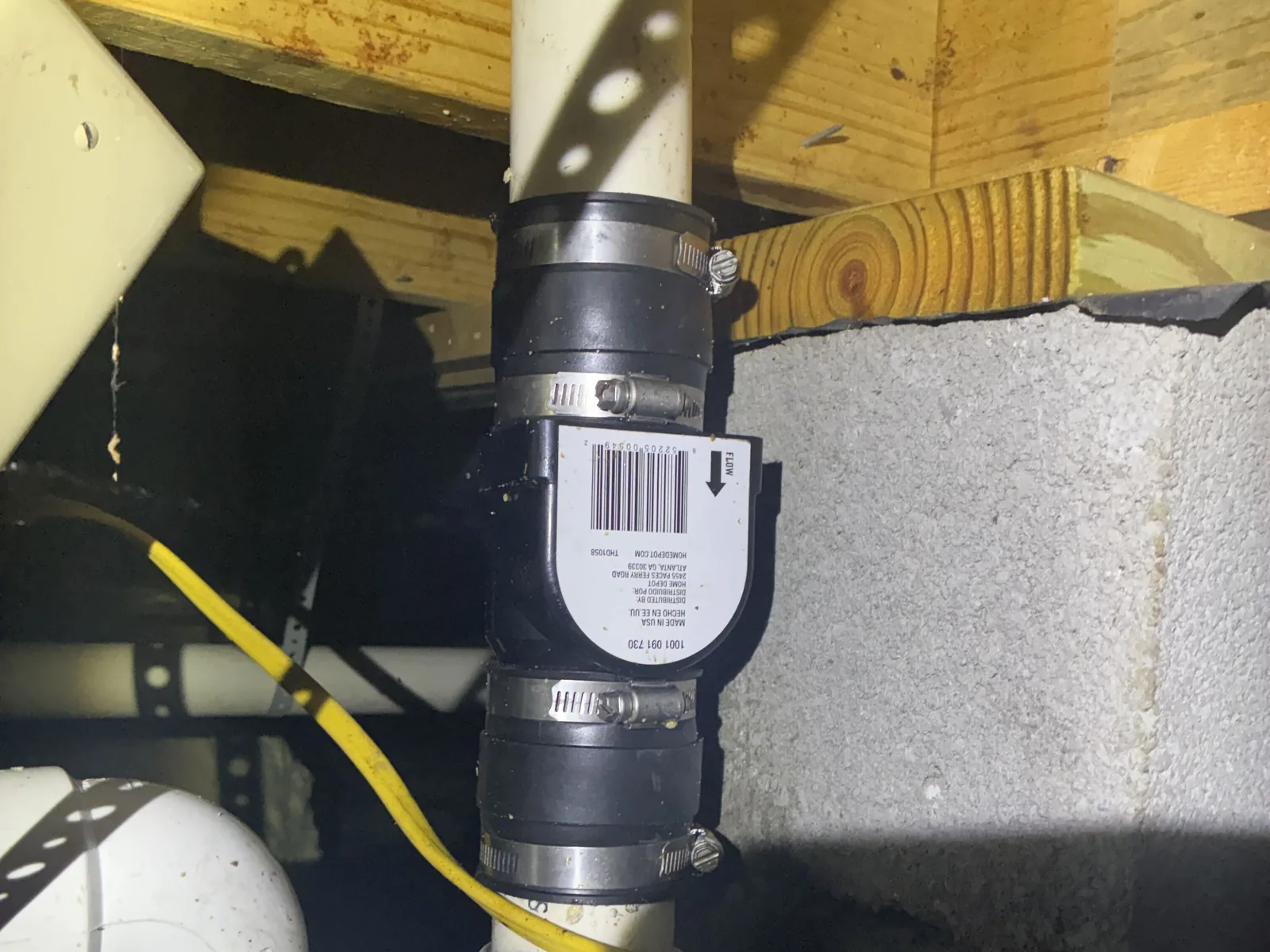 New check valve with flexible couplings on a drain line in a crawl space