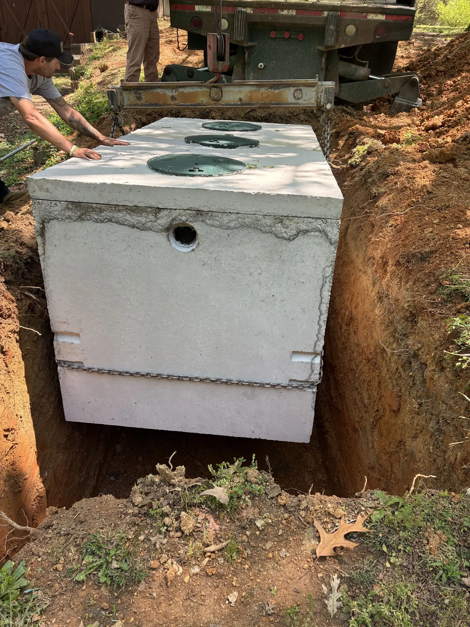 Precast septic tank being lowered into the dug hole